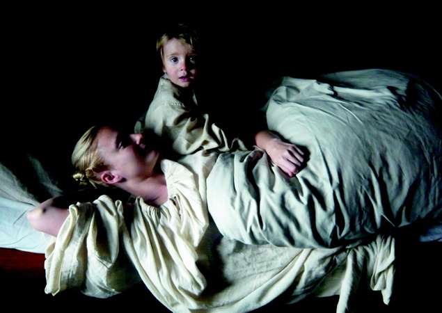 Une femme dans un lit avec son jeune enfant